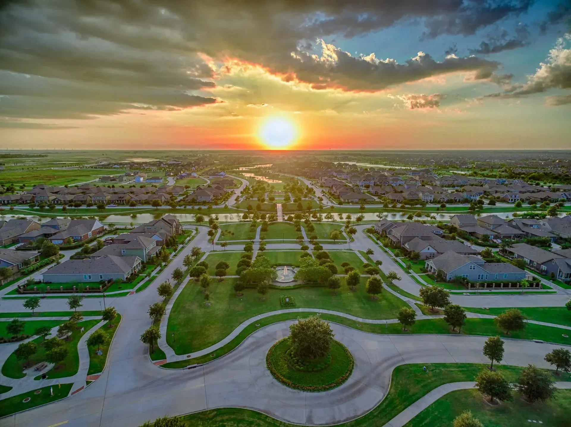 Drone view of Bridgeland at sunset over lakes, parks, and rooftops