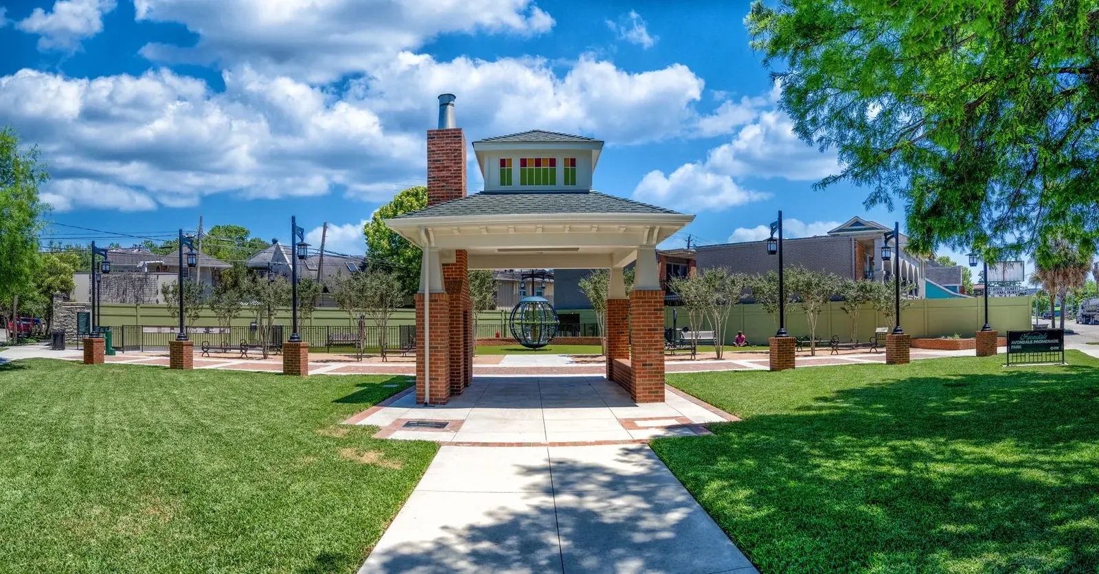 Brick pavilion in a civic park under a Texas sky