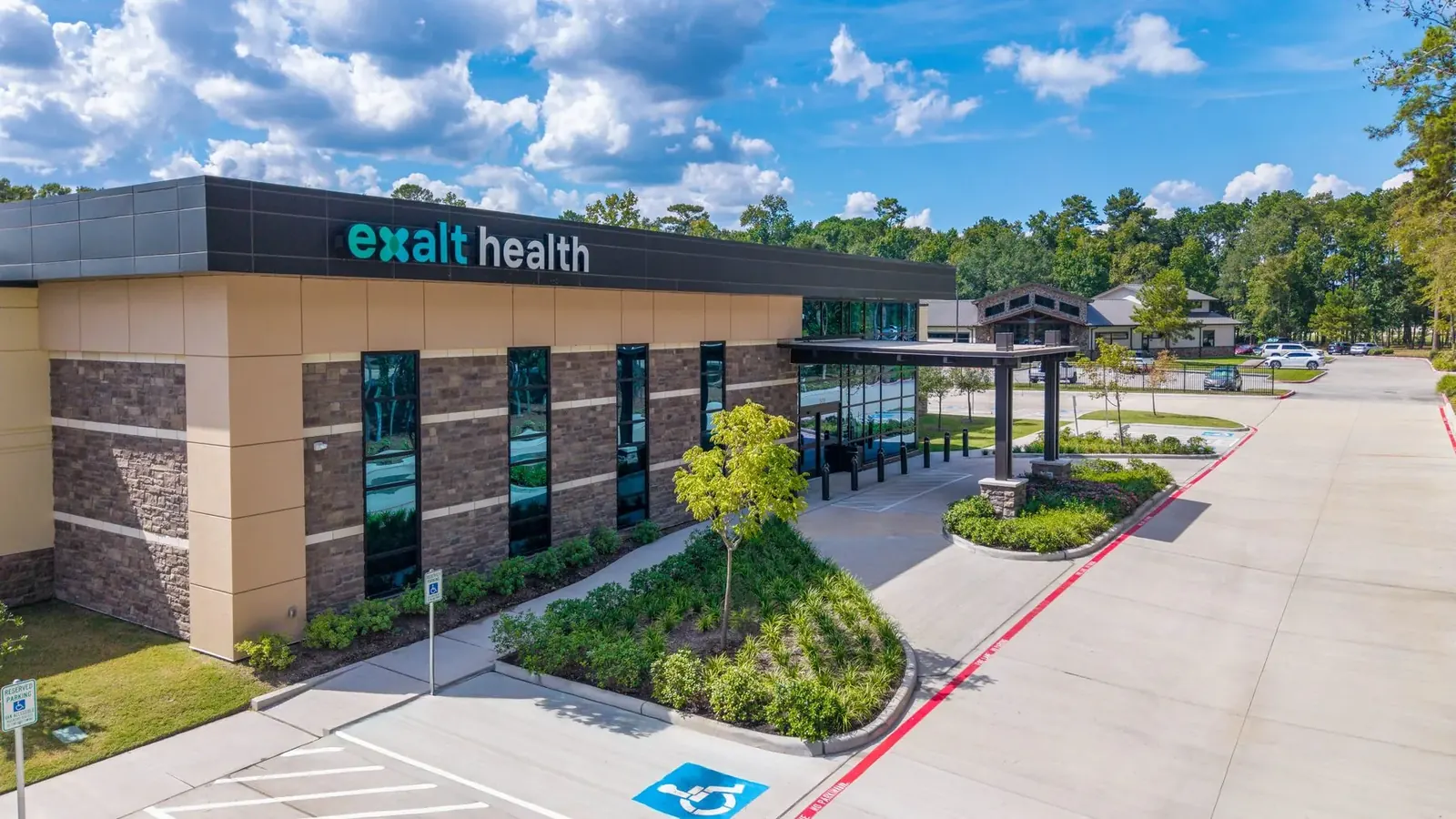 Exalt Health clinic exterior with porte-cochère and landscaping
